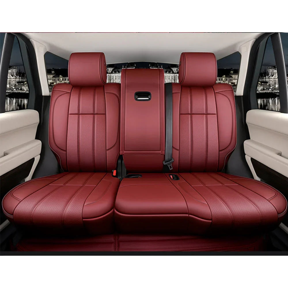 Matte burgundy leather car backseat with three headrests and beige interior accents