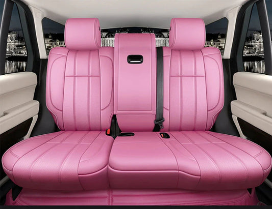 Backseat of luxury car with vibrant pink leather upholstery and beige interior panels