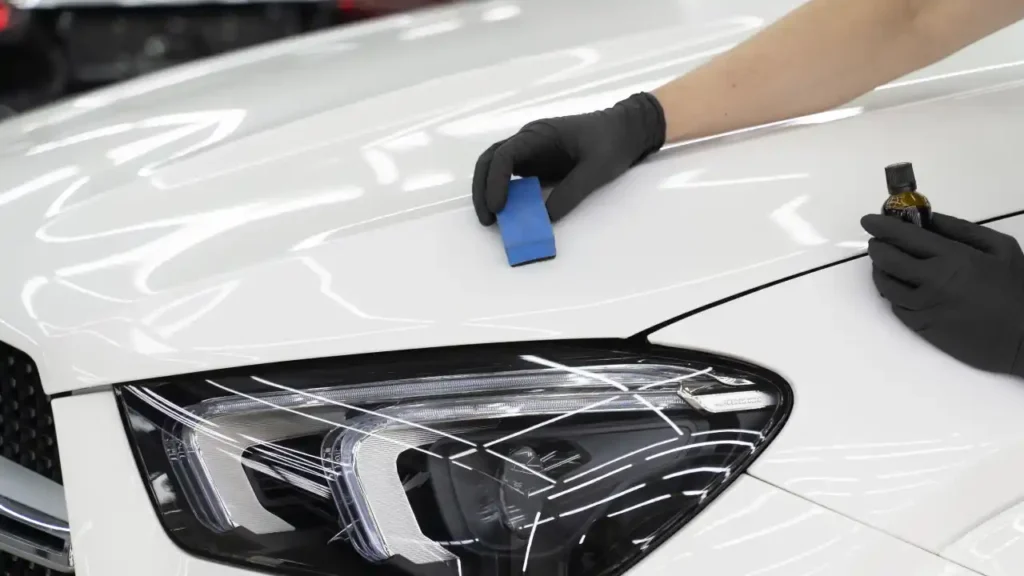 Professional ceramic coating application on white car hood for long-lasting protection