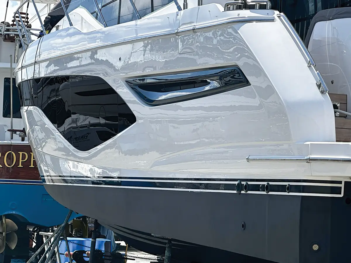 Boat detailing in Orleans restoring white yacht hull and gel coat finish at marina facility